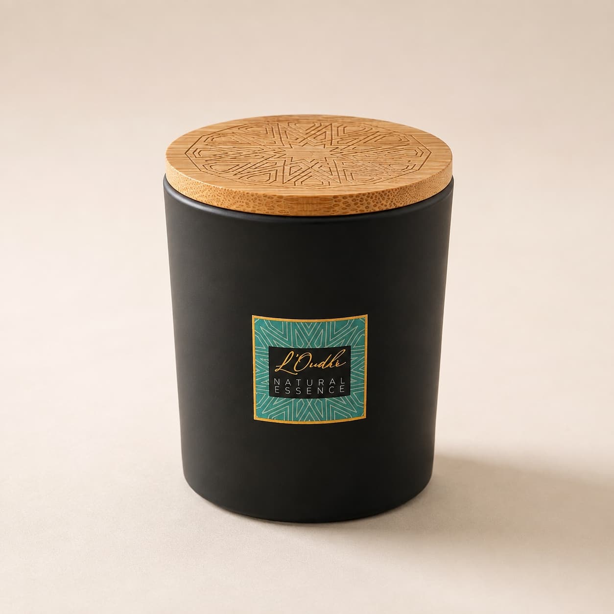 The Mindful Moment candle: a matte black jar with a teal and gold zellige label, closed with an engraved wooden lid.